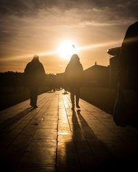 Rear view of silhouette people standing against sky during sunset