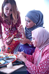 Portrait of smiling friends having food at home
