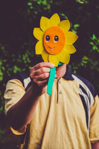 Close-up of hand holding yellow flower