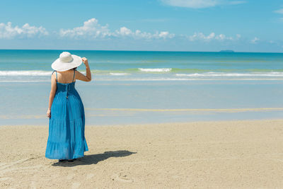 Rear view of woman standing on beach