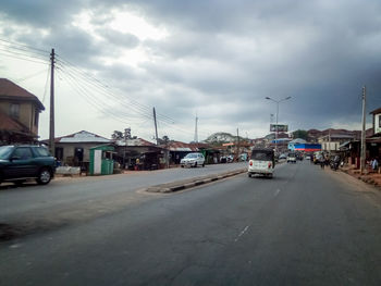 Cars on road in city against sky