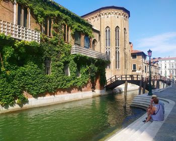 Canal amidst buildings against sky