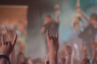 Midsection of people enjoying at music concert