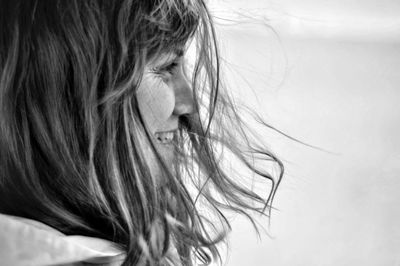 Close-up of woman with tousled hair looking away while sitting outdoors