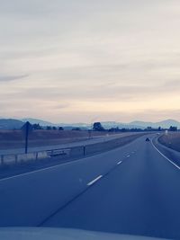 Road against sky seen through car windshield