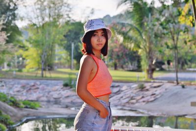 Full length of woman wearing hat standing against trees