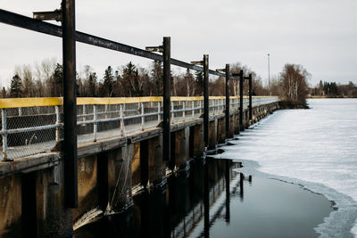 Ground level view of bridge reflecting in lake.