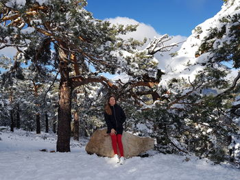 Full length of person standing on snow covered tree