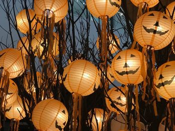 Low angle view of illuminated jack o lanterns hanging at night