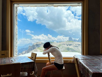 Woman sitting in the cafe overlooking the mountains