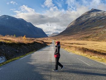 Rear view of woman walking on road