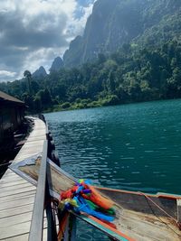 Scenic view of river by mountains against sky