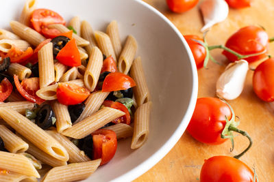 Penne pasta with tomatoes and black olives