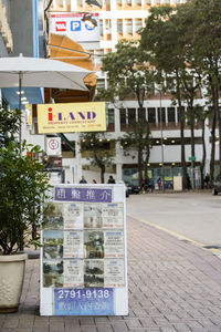 Road sign on street by buildings in city