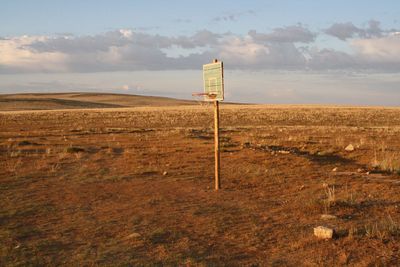 Basketball hoop on field against sky