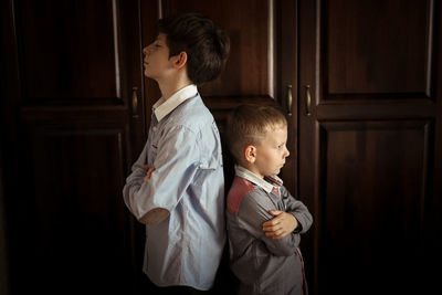 Brothers play and fight in a real interior, the concept of the opposition of siblings and family 