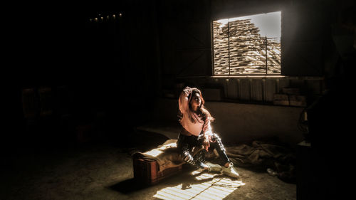 Man holding camera while sitting on table at home