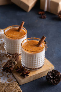 Traditional christmas drink and dessert eggnog with cinnamon and spices with handmade gift boxes