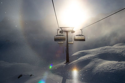 Low angle view of snow covered mountain against sky, with sundog optical effect