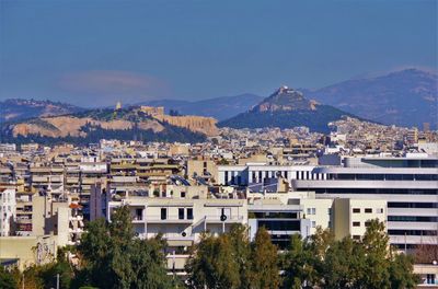 High angle view of townscape and mountains against clear sky