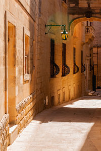 Buildings with old fashioned lanterns and balconies. ancient narrow street in mdina, malta.