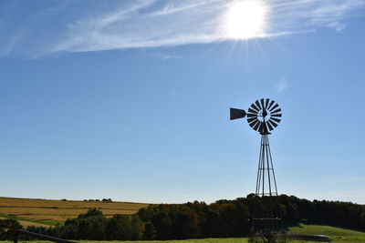 Low angle view of windmill on field against sky