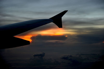 Cropped image of airplane flying over clouds