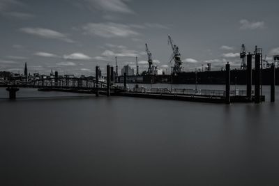 Bridge over elbe river at port of hamburg against sky