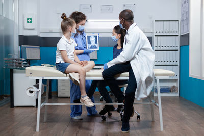 Side view of female doctor examining patient in hospital