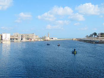 Scenic view of sea by buildings against sky