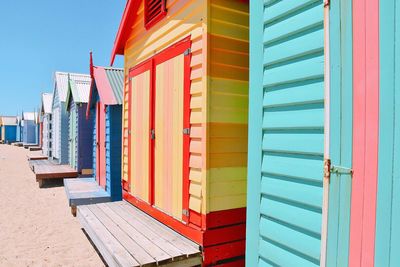 Multi colored beach huts against sky