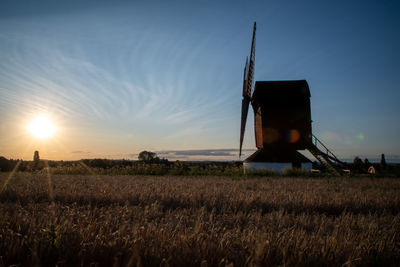 Built structure on field against sky during sunset