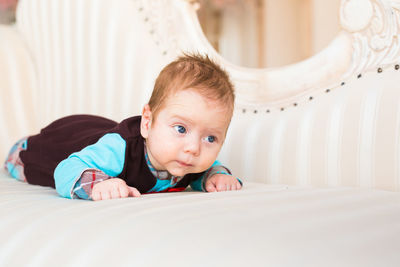 Portrait of cute girl lying on bed at home