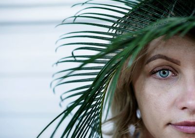 Close-up portrait of beautiful mid adult woman with leaves on head