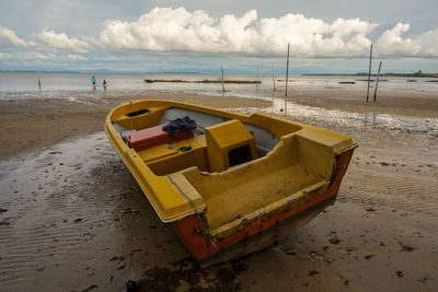 Boats moored on beach against sky