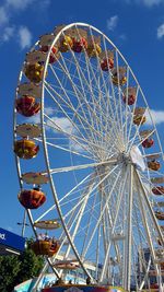 Low angle view of ferris wheel against blue sky