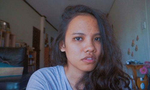 Close-up portrait of young woman at home