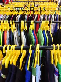 Multi colored t-shirts hanging on rack in store for sale
