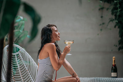 Full length of a young woman drinking glass