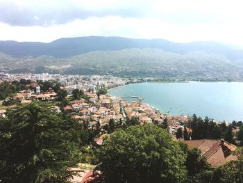 High angle view of townscape by sea against sky