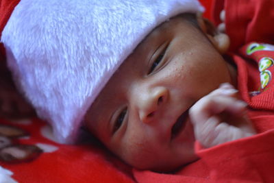 Close-up of cute baby boy lying on bed