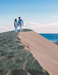 Rear view of woman walking on beach