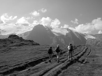 Rear view of people walking on mountain