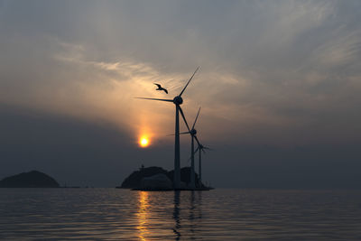 Silhouette of sailboats on sea against sky during sunset