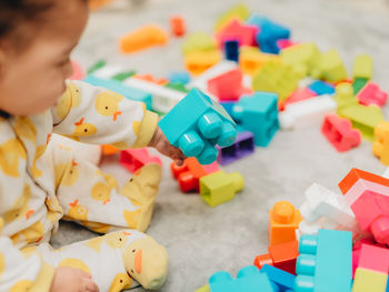 Cute kid playing with multi colored toys at home