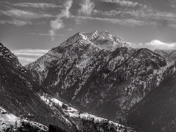 Scenic view of snow covered mountains against cloudy sky