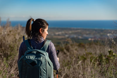 Woman contemplates the landscapes of the garraf natural park while walking the paths of a mountain.