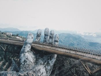 Bridge over mountain against sky