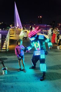 People at music concert in city at night