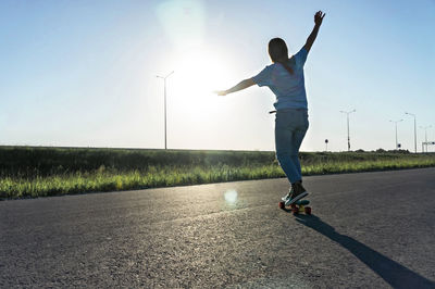 Full length of man walking on road against sky on sunny day